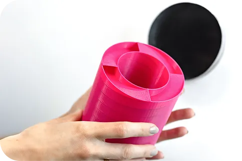 Photo showing a pink s|TWIST sound absorber held in hands, viewed from above. Its internal partitions and structure are visible, highlighting its innovative geometry.