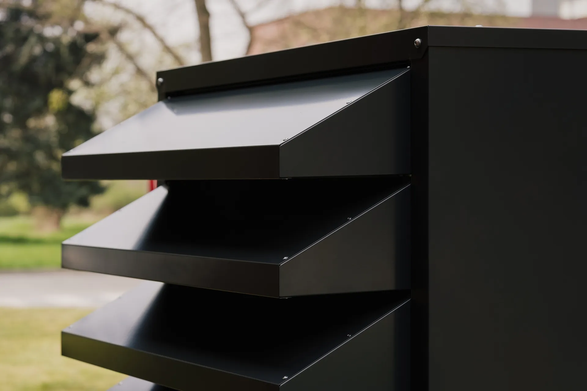 Close-up of the front of the black heat pump enclosure, highlighting its modern design.
